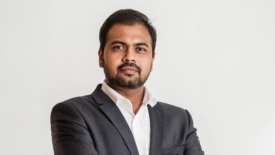 Anand Adhiappan in front of a white wall