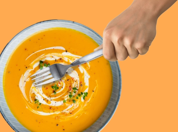 Someone is trying to eat soup with a fork. - Someone is trying to eat soup with a fork. -