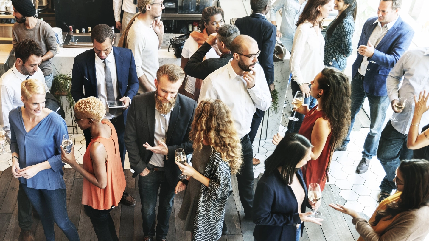 A group of people are attending and talking at an event. A group of people are attending and talking at an event.