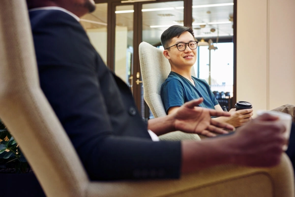 Two people sitting next to each other having a conversation - Business Finland