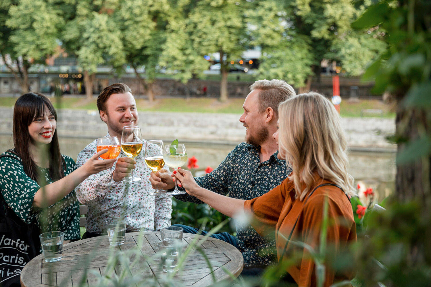 People dining by the river Aura in Turku.
