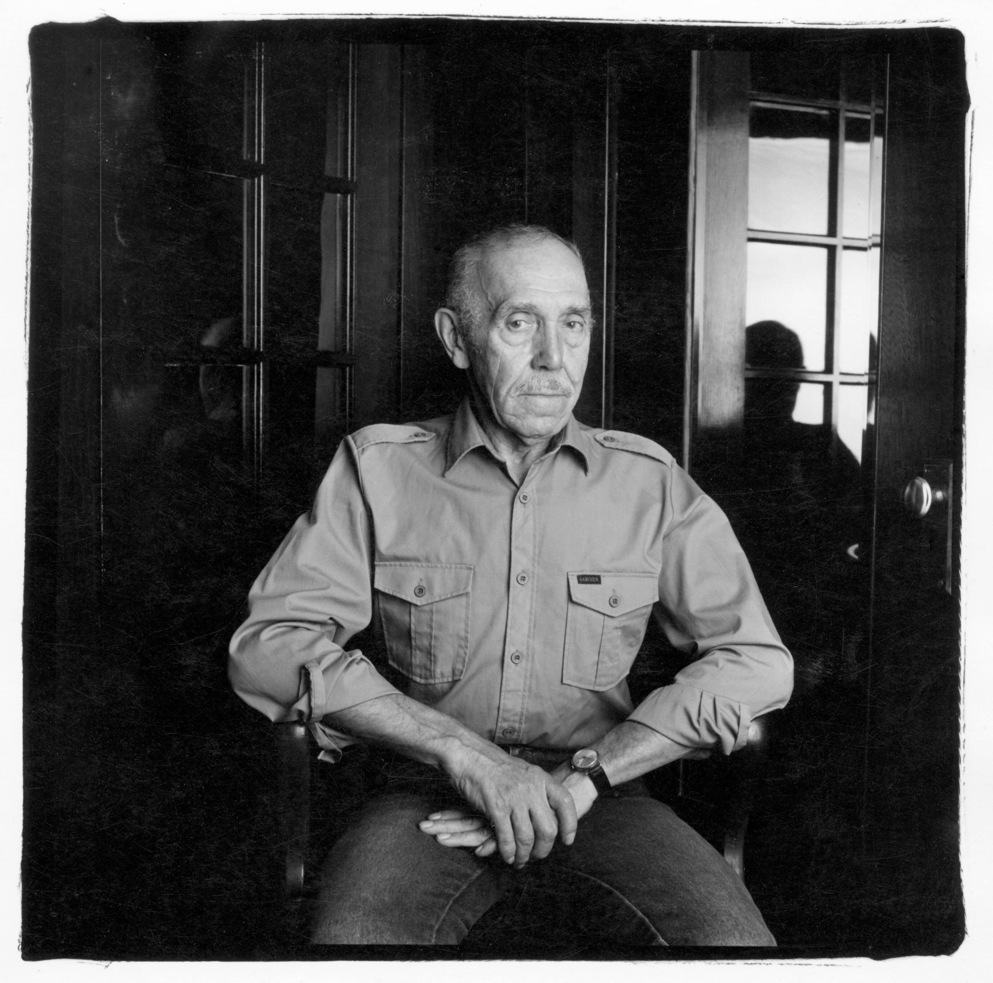 Touko Laaksonen, alias Tom of Finland, est assis sur une chaise.